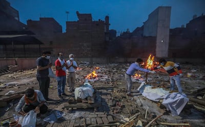 Family members perform the last rites of a Covid-19 victim at a makeshift cremation ground in New Delhi. EPA