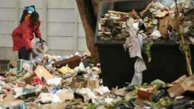 An unidentified man sifts through garbage in Harare.