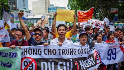 Vietnamese protesters shout slogans against a proposal to grant companies lengthy land leases during a demonstration in Ho Chi Minh City on June 10, 2018. The draft law at the centre of the furore would allow 99-year concessions in planned special economic zones, which some view as sweetheart deals for foreign and specifically Chinese firms. / AFP / Kao NGUYEN