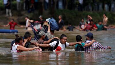 Migrants struggle to cross the river from Guatemala to Mexico in Ciudad Hidalgo. Reuters