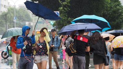 People cross the street under the rain in Taipei, Taiwan. According to The Central Weather Bureau, Typhoon Mitag is expected to bring strong wind and heavy rain to Taiwan between 30 September and 01 October, as it skirts Taiwan's east coast. EPA