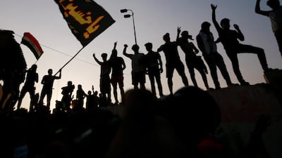 Iraqi protesters stand on concrete blast walls during a protest near the building of the government office in Basra. Reuters