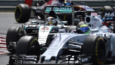 Mercedes-GP's Lewis Hamilton holds off the Williams of Felipe Massa, right, during the Hungarian Grand Prix. Andrej Isakovic / AFP