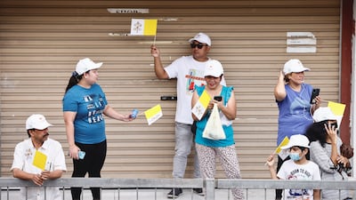 People wave Vatican City flags before the pope's arrival at the Sacred Heart Church. Reuters
