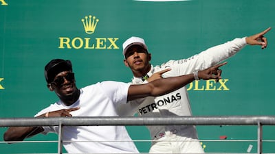 Usain Bolt shows Mercedes driver Lewis Hamilton how to celebrate a victory. Tony Gutierrez / AP Photo