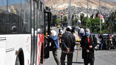 People board a bus at a station in Damascus, Syria on the first day of the government's decision to allow public and private transport to resume after an almost two-month stoppage. EPA