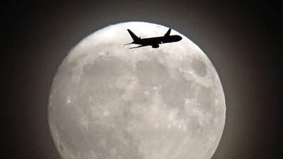 A commercial jet flies in front of the moon on its approach to Heathrow airport in west London on November 13, 2016. Adrian Dennis / AFP