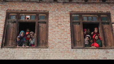Women and children watch as the bride leaves her house.