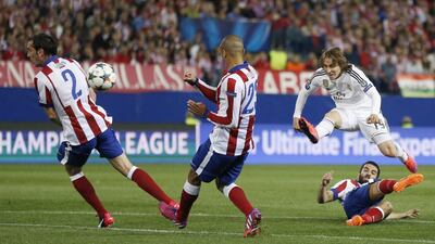 Real Madrid's Luka Modric shoots through Atletico Madrid's Diego Godin, left, and Miranda, centre, as well as over Arda Turan, bottom right, in the Champions League on Tuesday night. Daniel Ochoa de Olza / AP
