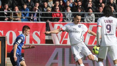 Paris Saint-Germain’s Swedish forward Zlatan Ibrahimovic (C) shoots and scores a goal despite Troyes’ French midfielder Alois Confais (L) during the French Ligue 1 football match between Troyes and Paris Saint-Germain on March 13, 2016 at the Aube Stadium in Troyes. PHOTO AFP / FRANCOIS NASCIMBENI