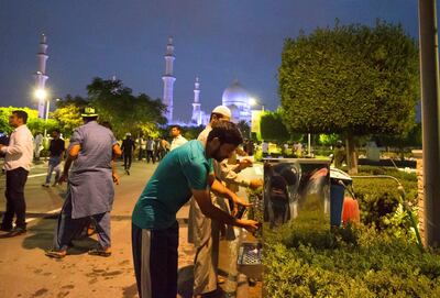 Men perform ablution ahead of praying maghrib at Sheikh Zayed Grand Mosque. Leslie Pableo for The National