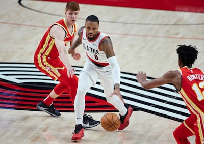 Portland Trail Blazers guard Damian Lillard dribbles past Atlanta Hawks guard Kevin Huerter. AP
