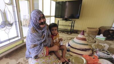 Wam resident Umm Mohammed, with her grandson Sultan Al Hafiti, 2, laments conditions in her hometown. Jeffrey E Biteng / The National