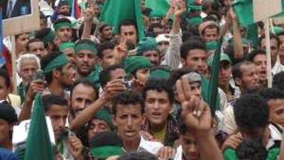 Protesters shout while holding up flags of the former South Yemen and posters of its former president Ali Salem al Baid.