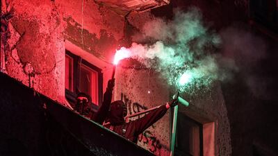 Protesters light flares on the balcony of a squatted house in the Friedrichshain district prior to May Day in Berlin, Germany. EPA