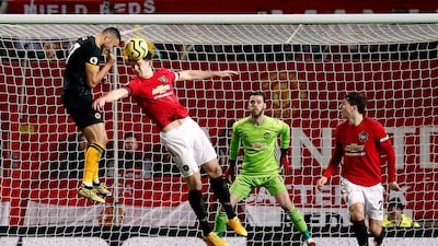 Manchester United's Harry Maguire heads the ball clear under pressure from Wolverhampton Wanderers' Romain Saiss. PA