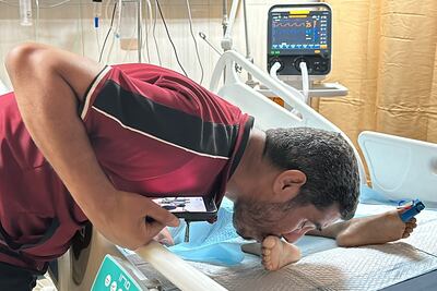 A father kisses his injured child's foot after an Israeli strike in Deir Al Balah, in the central Gaza Strip. Reuters