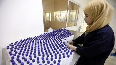 A Palestinian woman works at a factory manufacturing sanitisers, near the West Bank City of Jenin. EPA