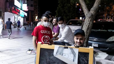 Binyamin, an artist, draws portraits on Al Rigga Street. Reem Mohammed / The National