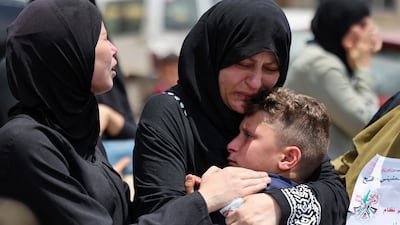Ruba Al Tamimi holds her son, Mahmoud, at the funeral of her other son, Muhammad, who died after being shot by Israeli troops during protests near Beita in the occupied West Bank on July 23, 2021. AFP