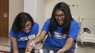 Giving and learning, Diniya Sunshine and Divya Dharshini at the Oasis, the oldest hospital in the UAE which is now in a new home, play with a child in the staff nursery. Antonie Robertson / The National
