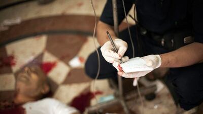 Syrian doctors are overworked at Dar Al Shifa hospital and here the name of a severely wounded man is taken as he is treated.