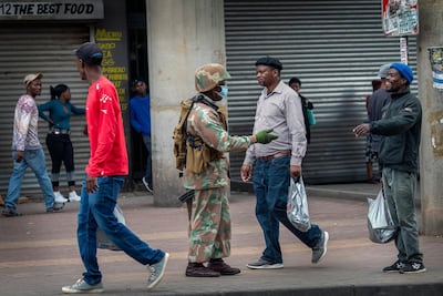 A South African National Defense Forces soldier ensures safe distance between people is respected in the commercial area of the Alexandra township of Johannesburg, South Africa, on April 3, 2020. AP Photo