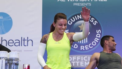Eva Clarke waves to supporters during her gruelling world record attempt for knuckle push-ups held at Abu Dhabi's Al Wahda Mall over the weekend. Mona Al Marzooqi/ The National