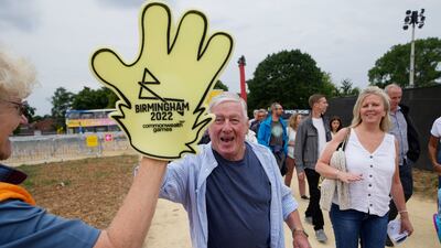 A man gives a high-five to a volunteer as people arrive for the opening ceremony. AP