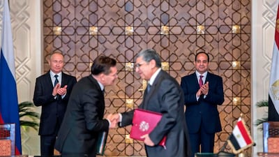 Egyptian president Abdel Fattah El Sisi, right, and his Russian counterpart Vladimir Putin, left, applaud as Egypt's electricity and renewable energy minister, Mohamed Shaker, right, shakes hands with Alexei Likkhachev, the director general of Russia's Atomic Energy Corporation, Rosatom, after signing an agreement to build a nuclear power plant in Egypt, in Cairo on December 11, 2017. Khaled Desouki / AFP