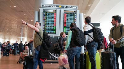 Travellers look at a monitor displaying delayed flights. Reuters