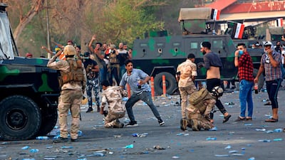 Security forces affected by tear gas are helped by several protesters during demonstrations in Basra. AP Photo