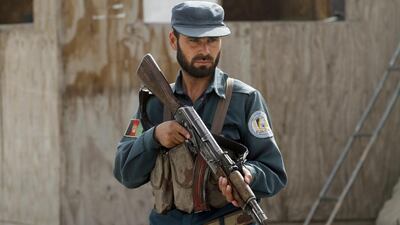 An Afghan policeman stands guard at his checkpoint in Kandahar, Afghanistan. A rogue Afghan policeman drugged and then shot dead 10 of his colleagues early Tuesday, the second insider attack on police in just over a week. Allauddin Khan/ AP Photo