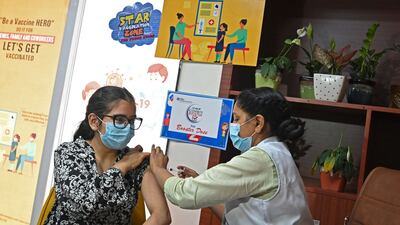 A health worker inoculates a girl with a dose of the Covaxin vaccine against the Covid-19 coronavirus at a vaccination centre in New Delhi on April 10, 2022, after government announced the paid precaution dose against Covid-19 coronavirus to be available for everyone above 18 years of age at private vaccination centres. AFP