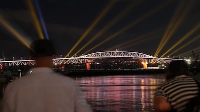 Auckland Harbour Bridge light show beams colorful lights across the sky in New Zealand. Getty Images
