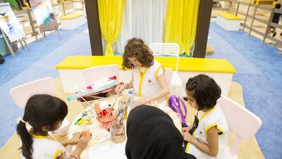 Dania Shell, 10, top, makes colourful work at Sayfuna Mumayaz’s arts and crafts programme hosted by Adec at Yas Mall. The number of participants is climbing by 1,000 a day. Christopher Pike / The National