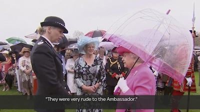 In image made from pool video, Queen Elizabeth II speaks with Metropolitan Police Commander Lucy D'Orsi in the garden of Buckingham Palace in London. The Queen has been overheard on video describing Chinese officials as "very rude to the ambassador". Subtitles as appears on source video. Pool Video via AP Video