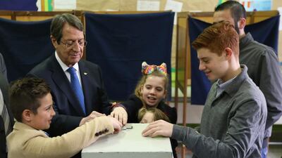 President Nicos Anastasiades, escorted by his grandchildren, votes during the presidential elections in the southern coastal city of Limassol. Petros Karadjias / AP
