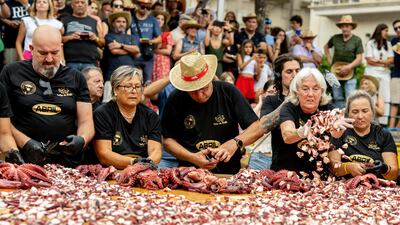 Pulpeiras and pulpeiros from O Carballino town prepare a new giant 600 kilo octopus tapa to break a new world record, at the Plaza Mayor in O Carballino, Spain, 05 August 2025. EPA / BRAIS LORENZO