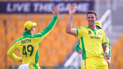 Australia's Josh Hazlewood celebrates with team mate Steve Smith after the dismissal of South Africa's Quinton de Kock during their T20 World Cup match at the Zayed Cricket Stadium in Abu Dhabi on Saturday, October 23, 2021. EPA