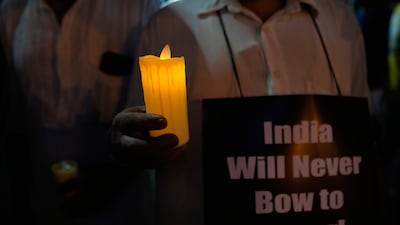 People in Kolkata, India, walk with candles and banners during a protest march against the killings in Kashmir. AP