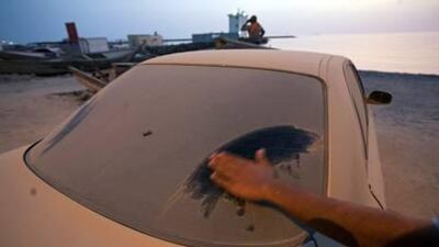 Areas in Ras al Khaimah and Fujairah have long suffered from poor air quality because of the large number of quarries. Above, a car owner wipes dust settled on the car’s rear window in RAK’s Ghalilah village.
