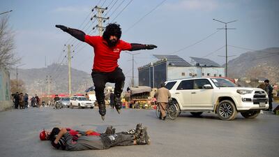 Youths perform stunts on roller-skates, during a car racing competition in Kabul. AFP