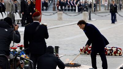 Emmanuel Macron lights the flame at the Tomb of the Unknown Soldier. AFP