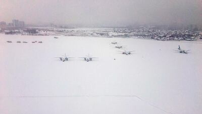 A picture taken through the window of a landing airplane shows snow covered aircrafts on the tarmac of Sofia airport on February 26, 2018. Dimitar Dilkoff / AFP