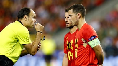 Referee Antonio Lahoz speaks with Belgium's Eden Hazard and Dries Mertens. Reuters