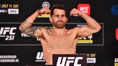 Alexander Volkanovski of Australia poses on the scale during the UFC 251 official weigh-in.