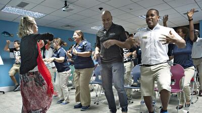 Wellness coach Susan Fitzgerald leads an exercise session for Wild Wadi employees that she suggests will alleviate stress and can be done during work breaks. Jeff Topping for The National
