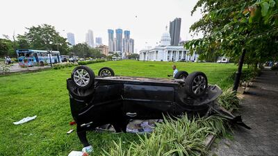 Destroyed vehicles litter the street after anti-government protesters rioted in Colombo. AFP