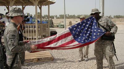 US soldiers fold the American flag while preparing to leave Scania military base in Hila, south of Baghdad, in 2010. EPA